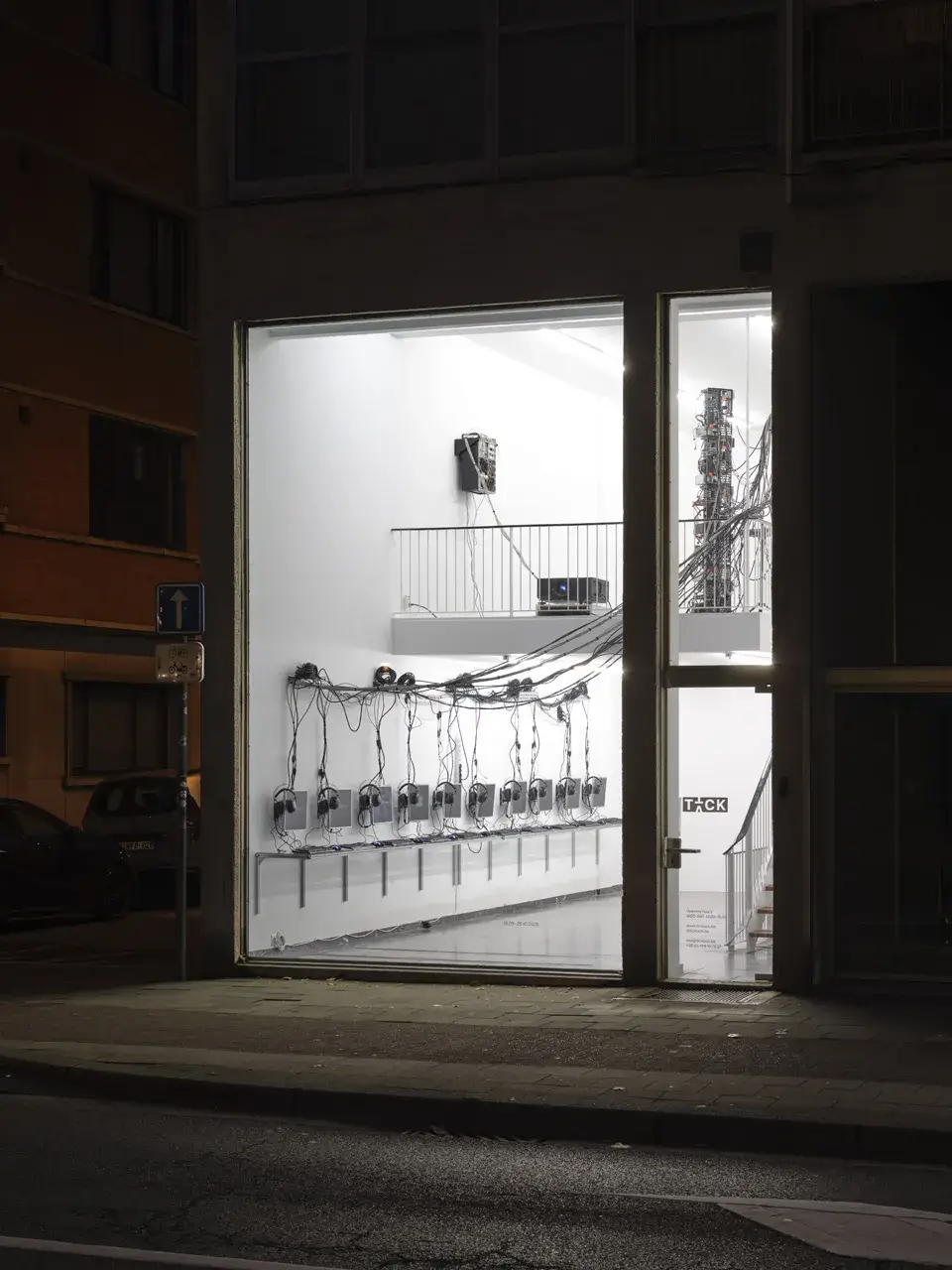Exterior shot of gallery in Antwerp with glass front displaying LAN by Brennan Wojtyla.
