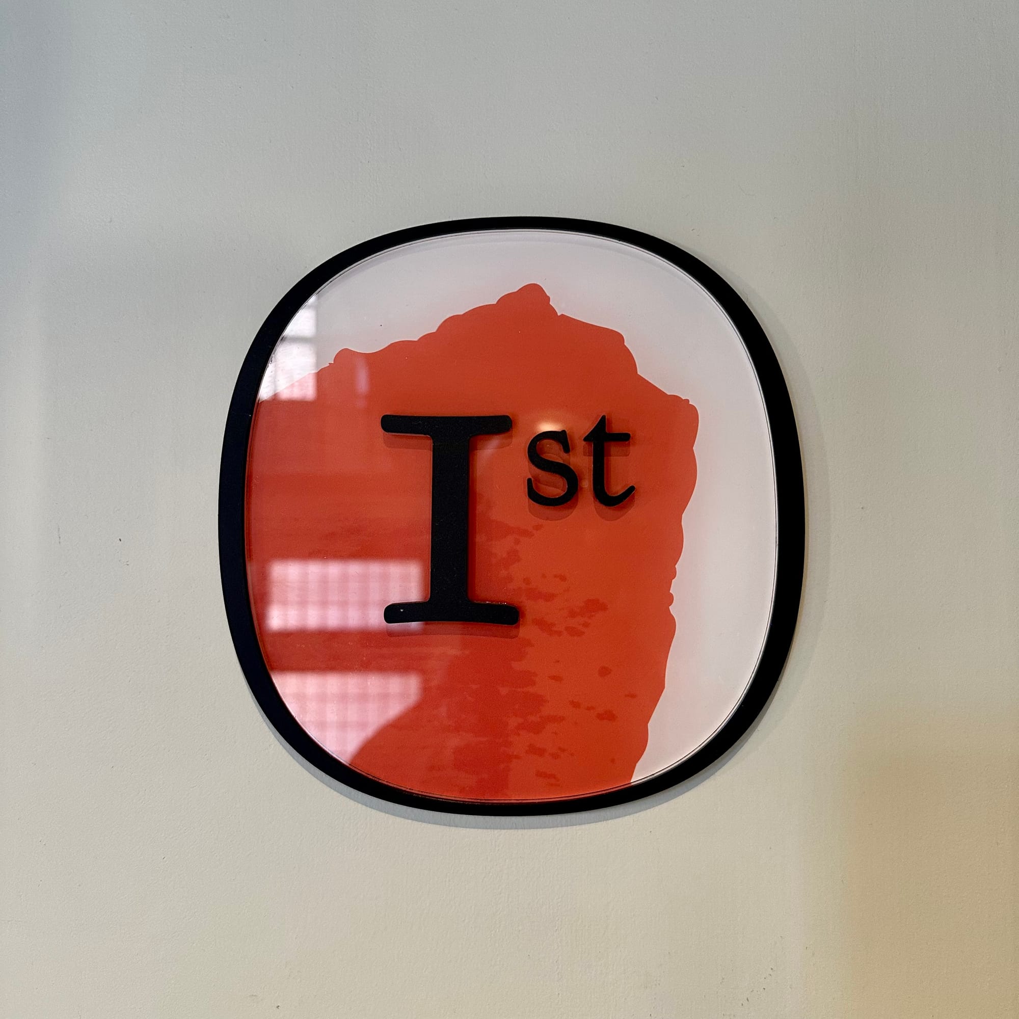 Stylised circular "1st" sign.