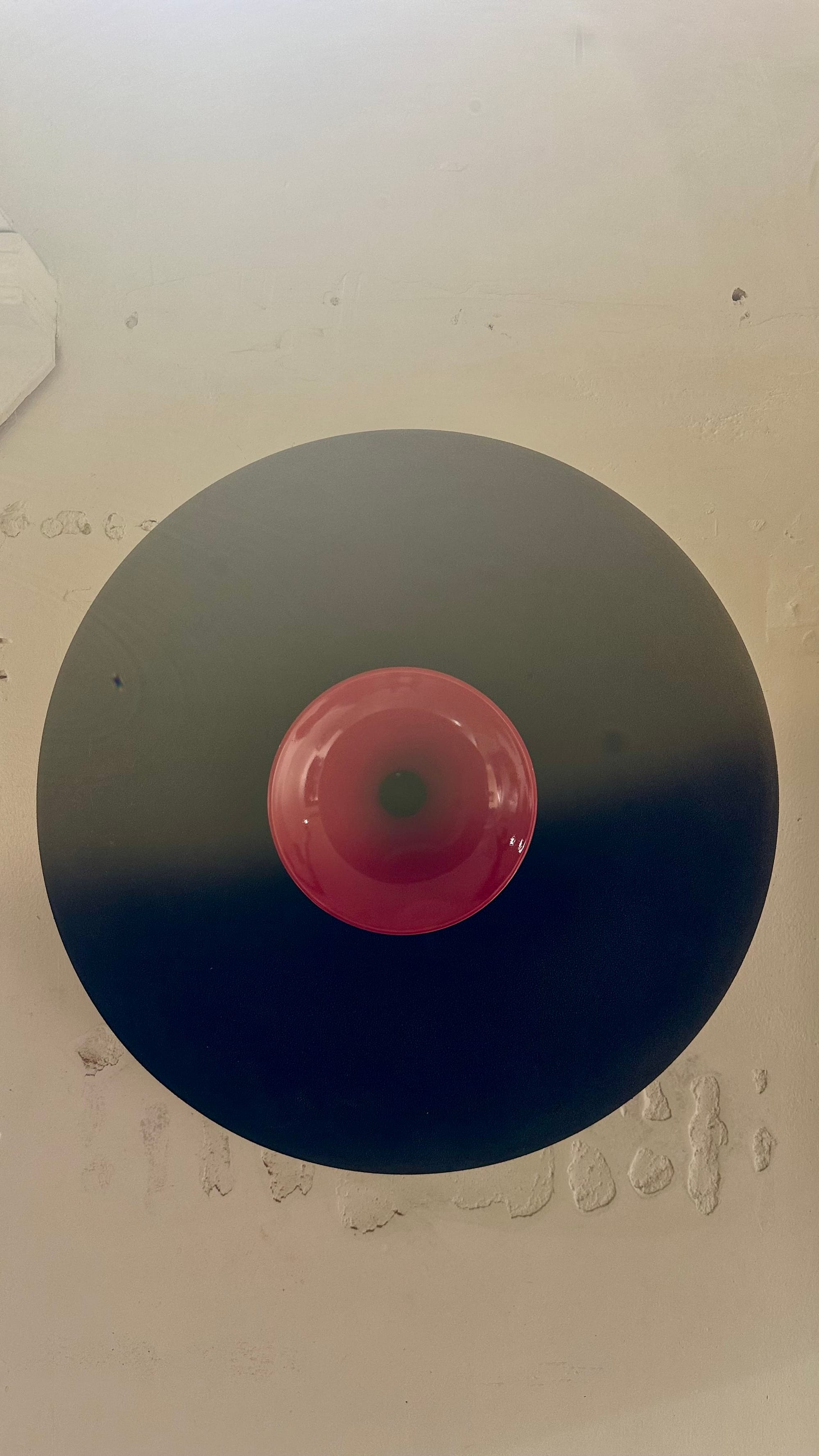 Circular speaker with black wide skirt and red tweeter.