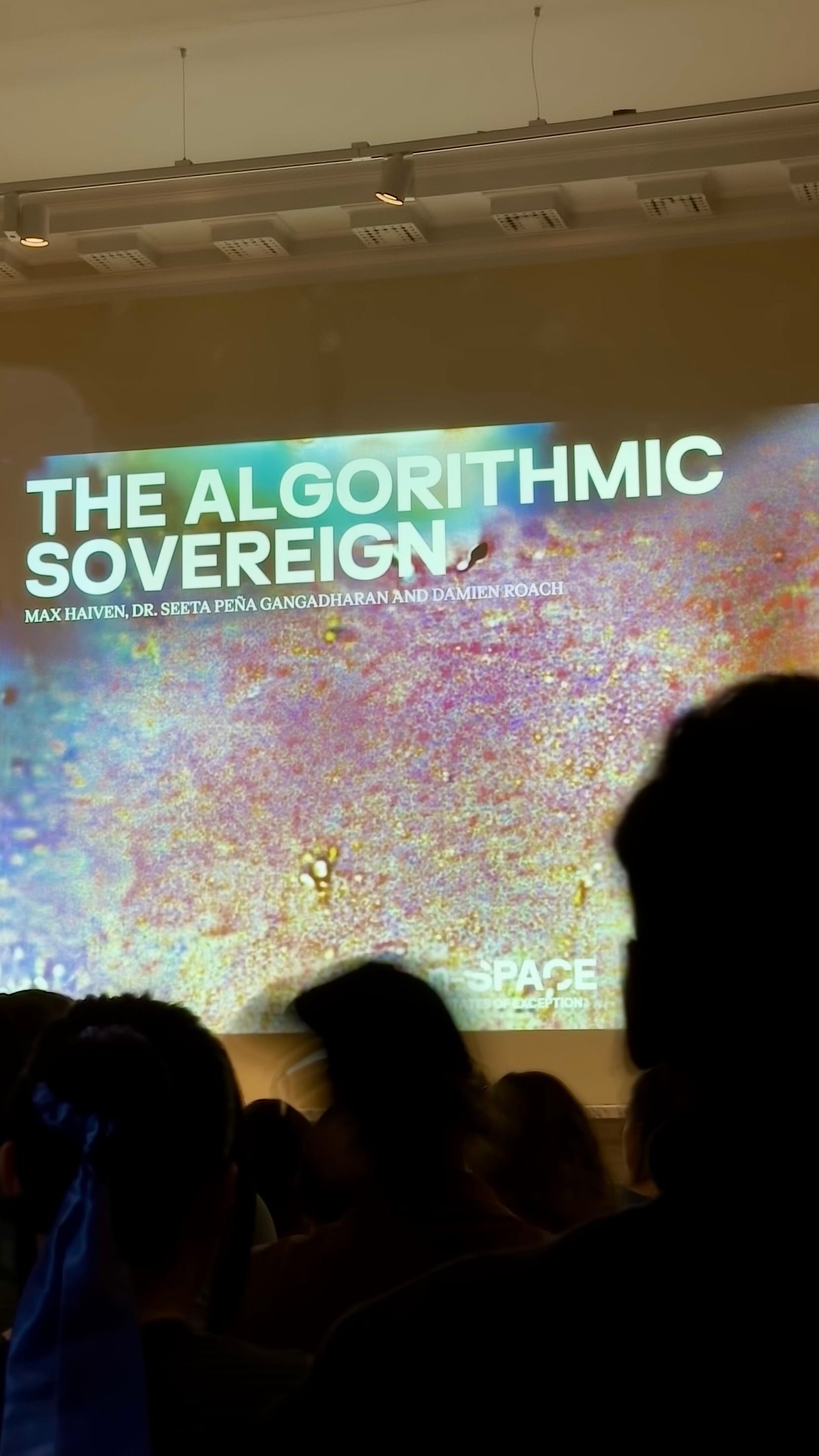 Photo of projector screen in an event called The Algorithmic Sovereign at Somerset House featuring Max Haven, Dr. Seeta Peña Ganghadharan, and Damien Roach.