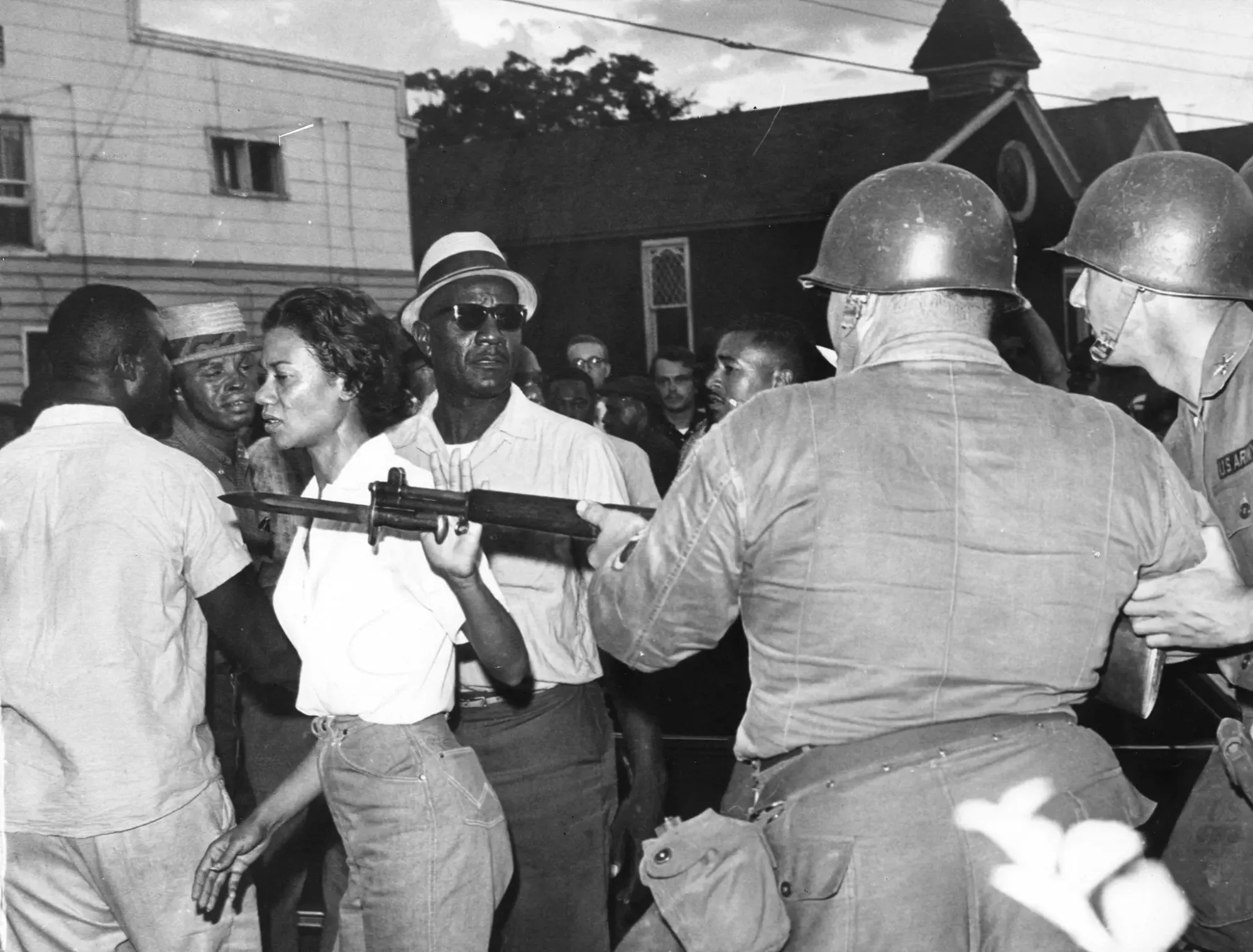 Famous protest photo of a black woman walking past National Guard men pushing aside their rifles.