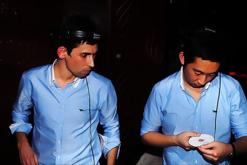 Gildas & Masaya DJing wearing matching Kitsuné blue oxford shirts. Source as above.