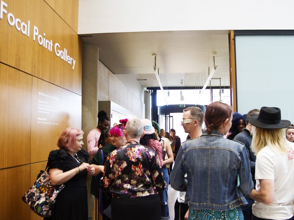 Entrance atrium at Focal Point Gallery in Southend-on-Sea showing various people standing in small groups and talking