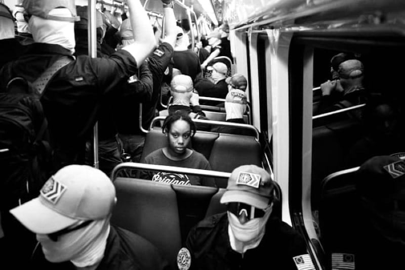 Young black woman commuter on Washington DC metro surrounded by masked white nationalists, 4 July 2026.