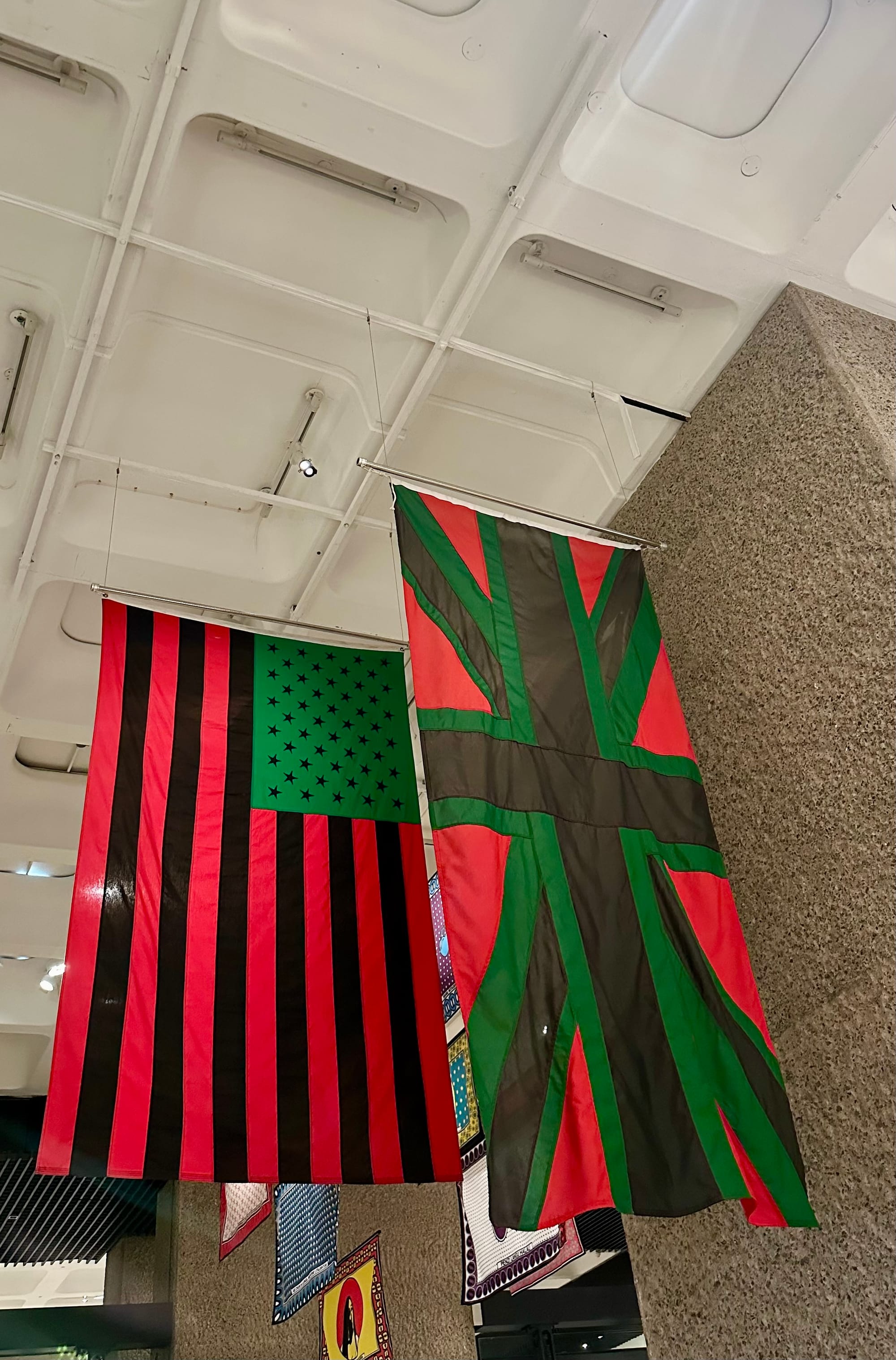 Giant flags of USA and UK hanging from the ceiling in Pan-African colours of red-black-green.