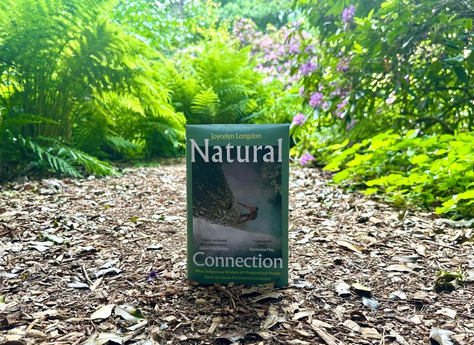 Photo of a book titled “Natural Connection” by Joycelyn Longdon, shown on a wood chipping patch in the Botanical Gardens at Kew in London.