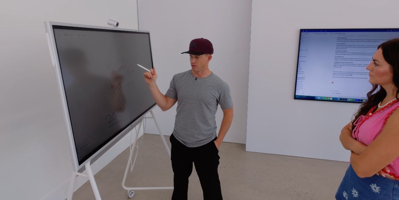 Paul at the whiteboard mid explanation with Tianna standing beside him listening