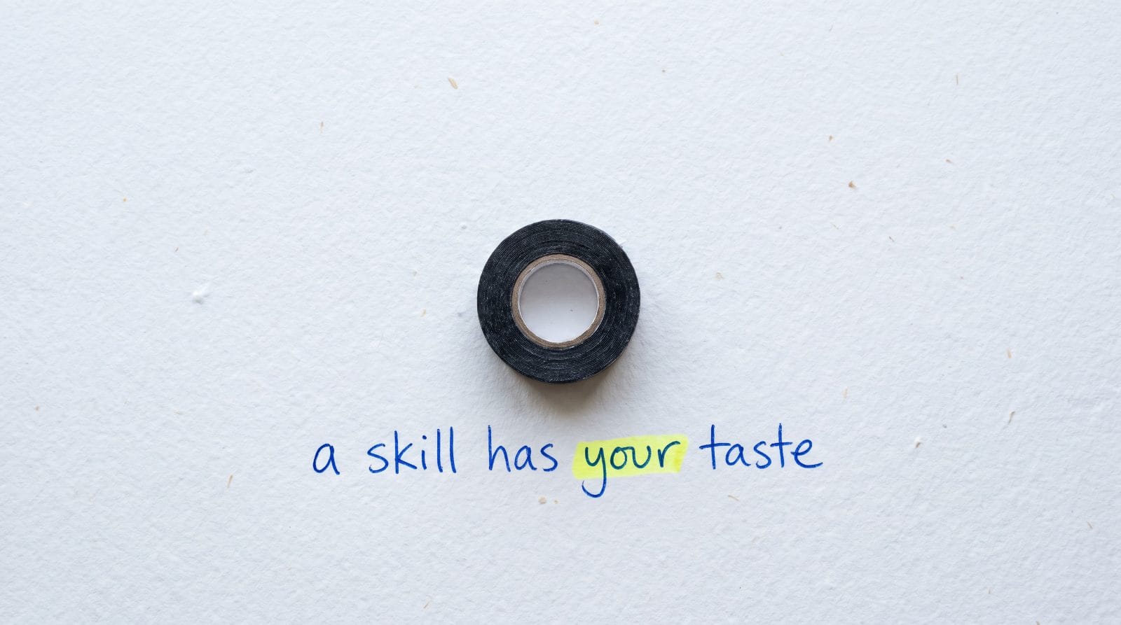 A roll of black tape on white paper with the handwritten words: a skill has your taste. The word your is highlighted.