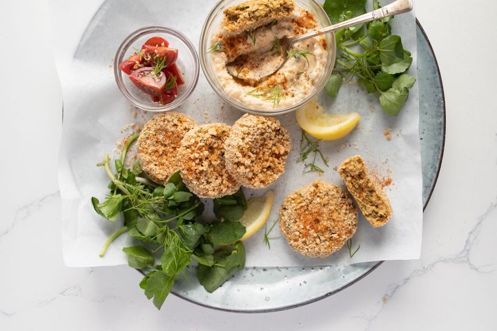 Fermented raw vegan crab cakes on a light blue plate and white marble background