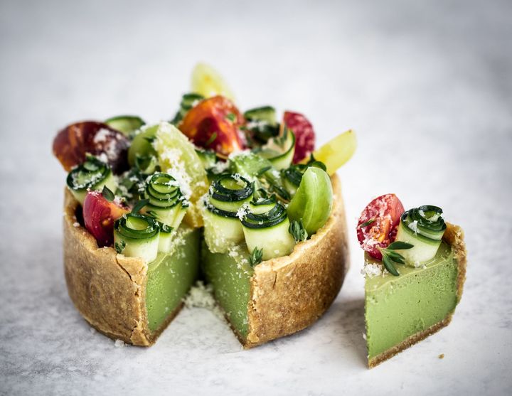 Raw vegan tomato basil tart on a white and grey background