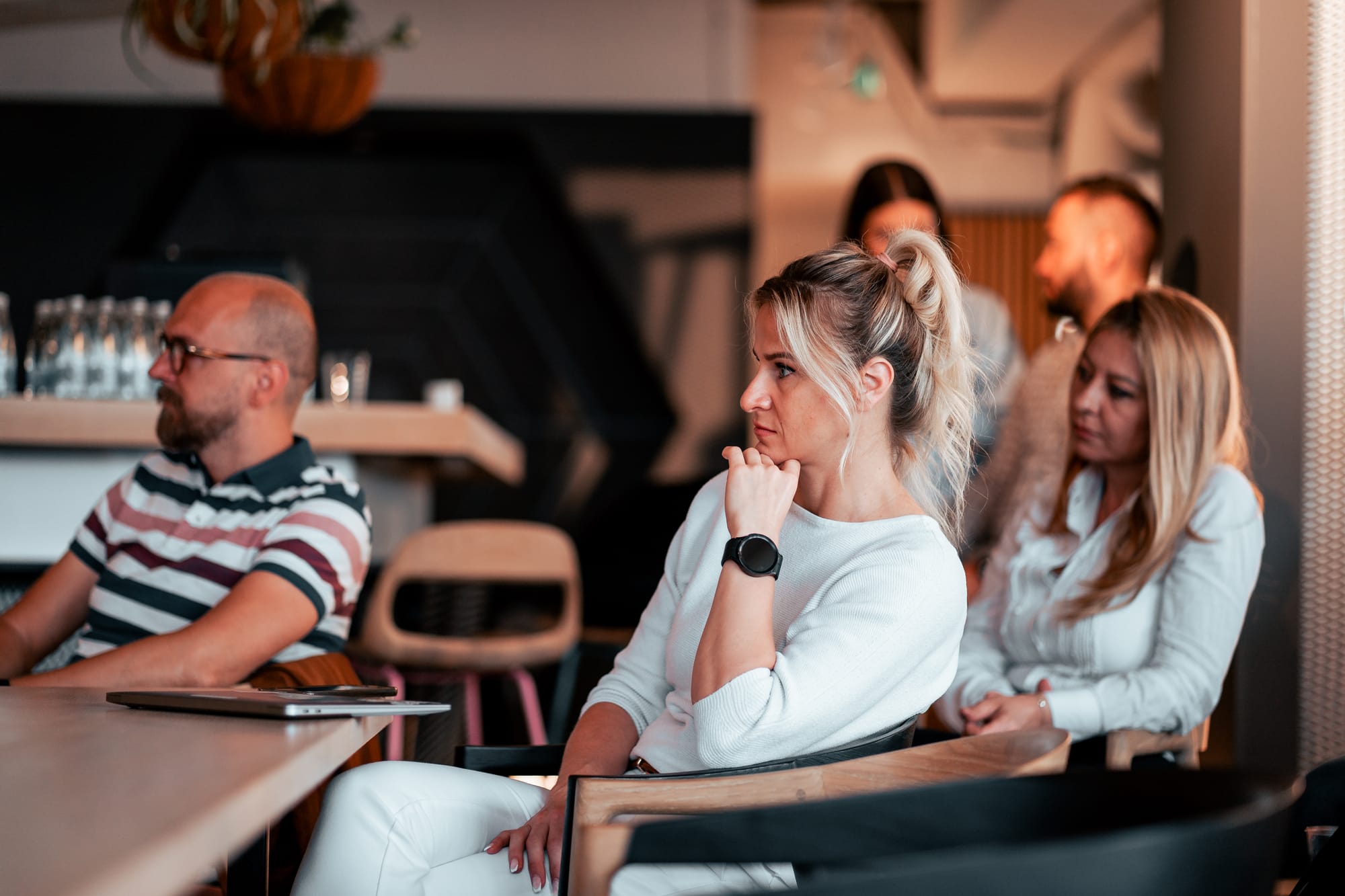 Group of professionals attentively listening during a startup business presentation in a modern workspace.