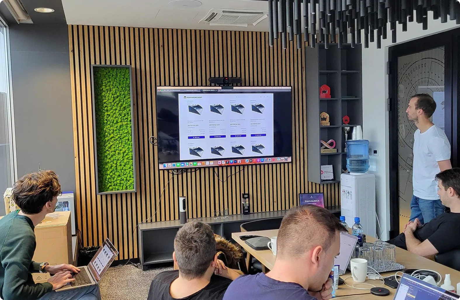 Team reviewing a digital product interface on a screen during a brand system alignment session, ensuring consistent UI patterns and visual identity.