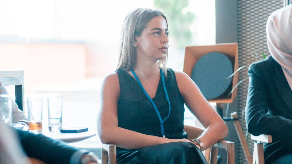 Software engineer attentively listening during a startup business pitch.