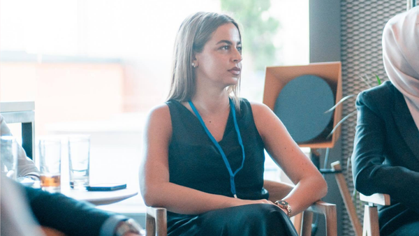 Software engineer attentively listening during a startup business pitch.