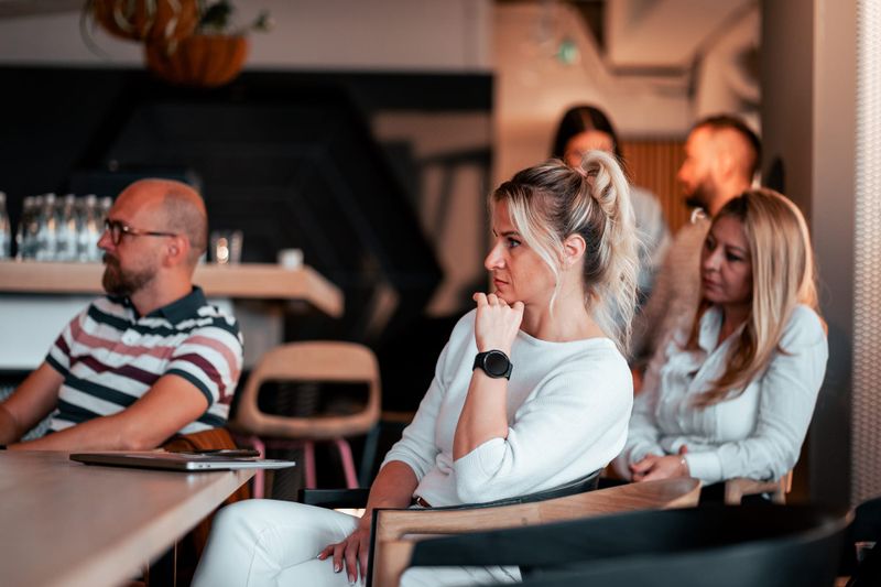 Group of professionals attentively listening during a startup business presentation in a modern workspace.