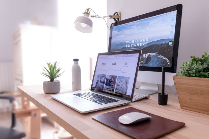 A professional workspace with a clean laptop and a notebook, symbolizing a streamlined marketing infrastructure for solopreneurs.