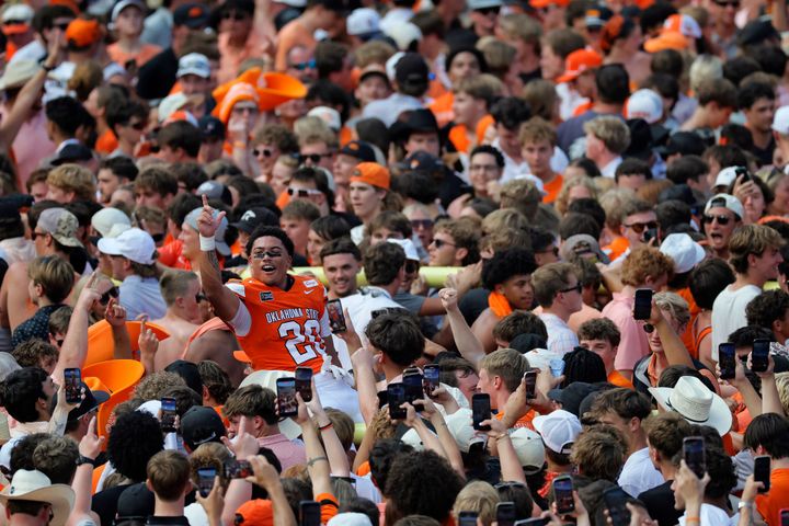 STILLWATER, OKLAHOMA - SEPTEMBER 12: Running back KD Jones #20 of the Oklahoma State Cowboys celebrates with the fans as they parade a goal post across the field after defeating the Oregon Du