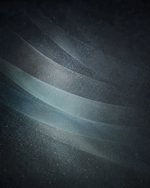 Abstract dark grainy background with several thin translucent curved ribbons sweeping diagonally and catching soft pale blue-grey light 