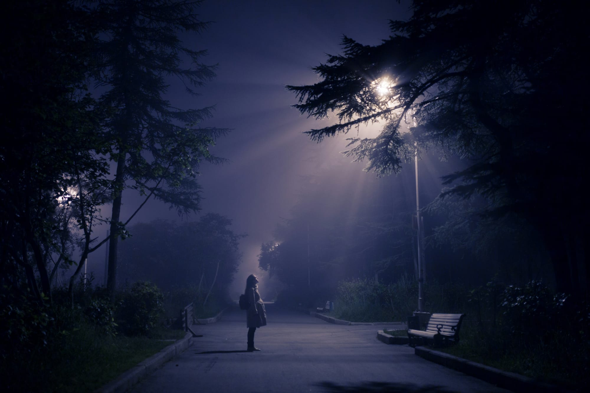 Woman looking up at light in the sky