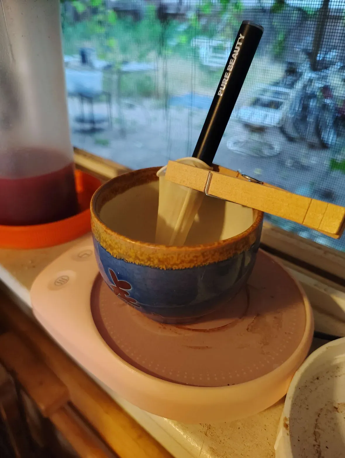 vape pen in a cup to warm, cup is shown here without water