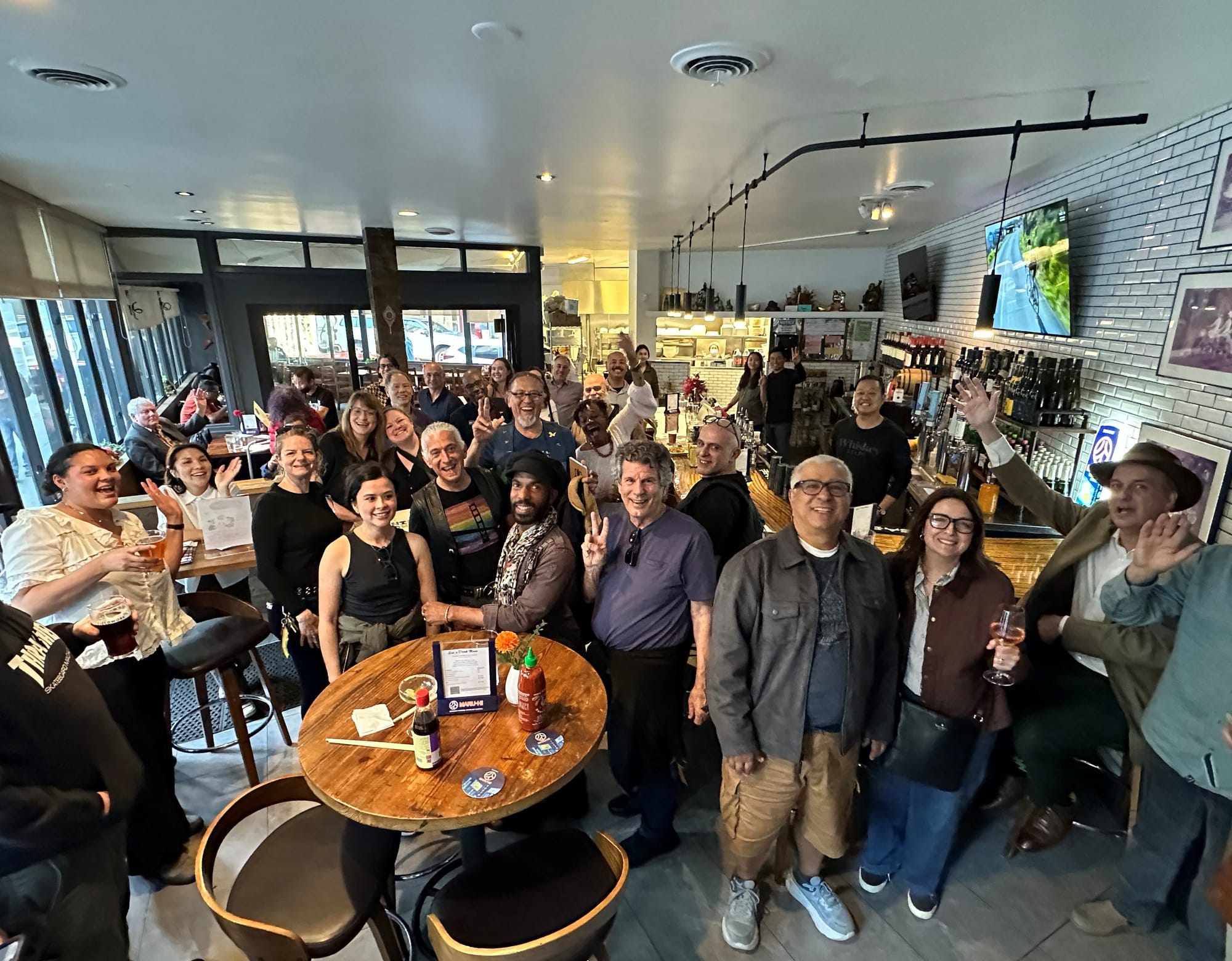 A group of ~35 people inside a restaurant space smiling for the camera.