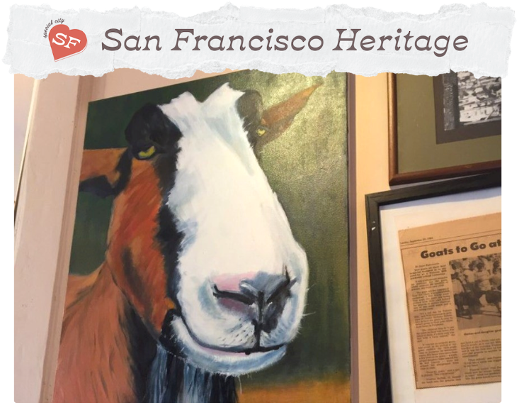 Oil painting on a wall showing a goat's face, with an orange and white coat and yellow eyes.