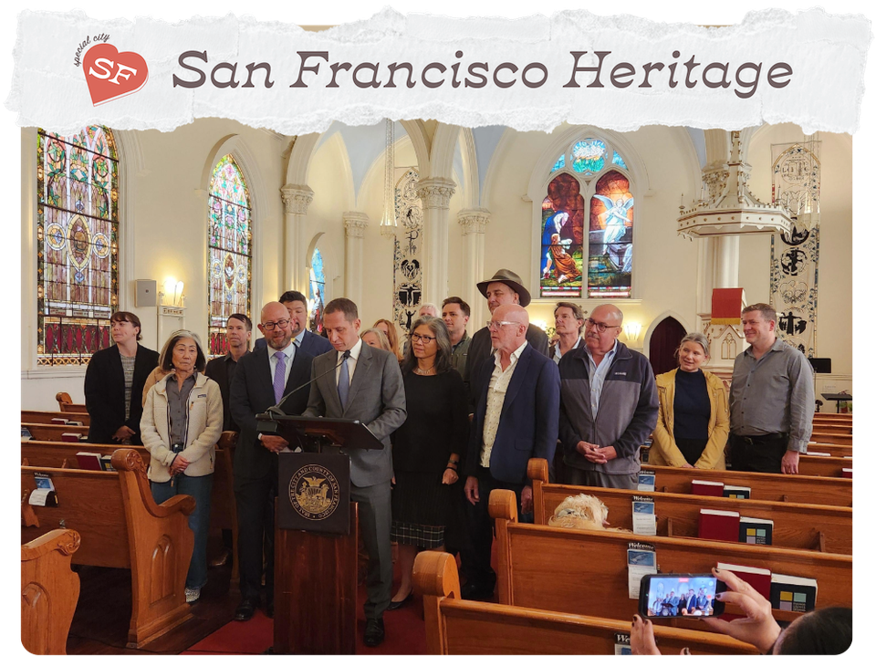A group of people inside a church with white archways, man in grey suit standing behind a podium featuring seal of the city of San Francisco.