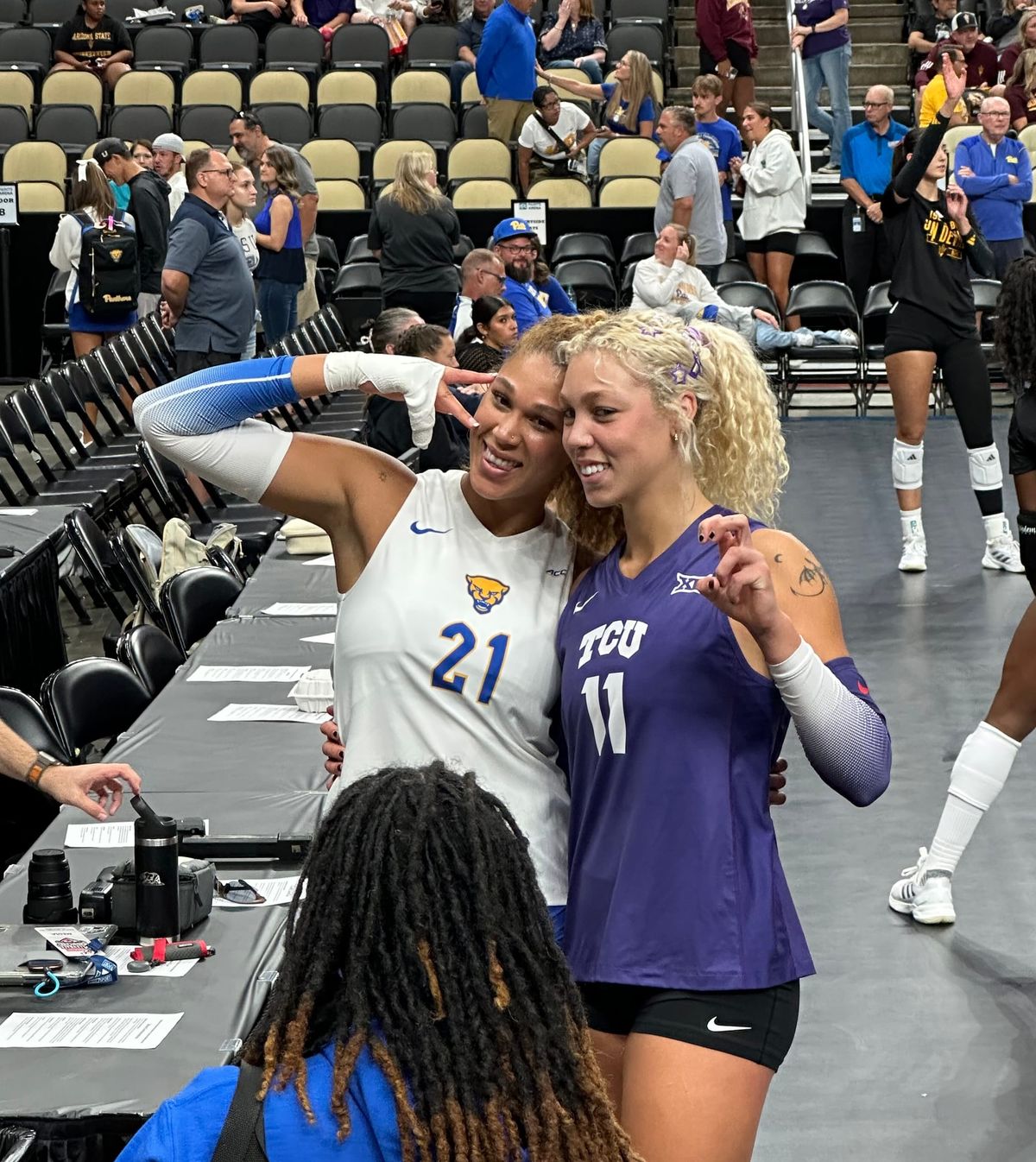 Post-match photo on the floor of PPG Paints Arena shows Bre Kelley posing with younger sister Becca, each in their volleyball uniforms