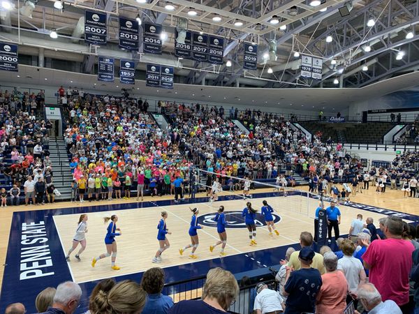 A 2019 photo inside the Rec Hall volleyball arena at Penn State, showing a sold out crowd and players warming up on the court before first serve