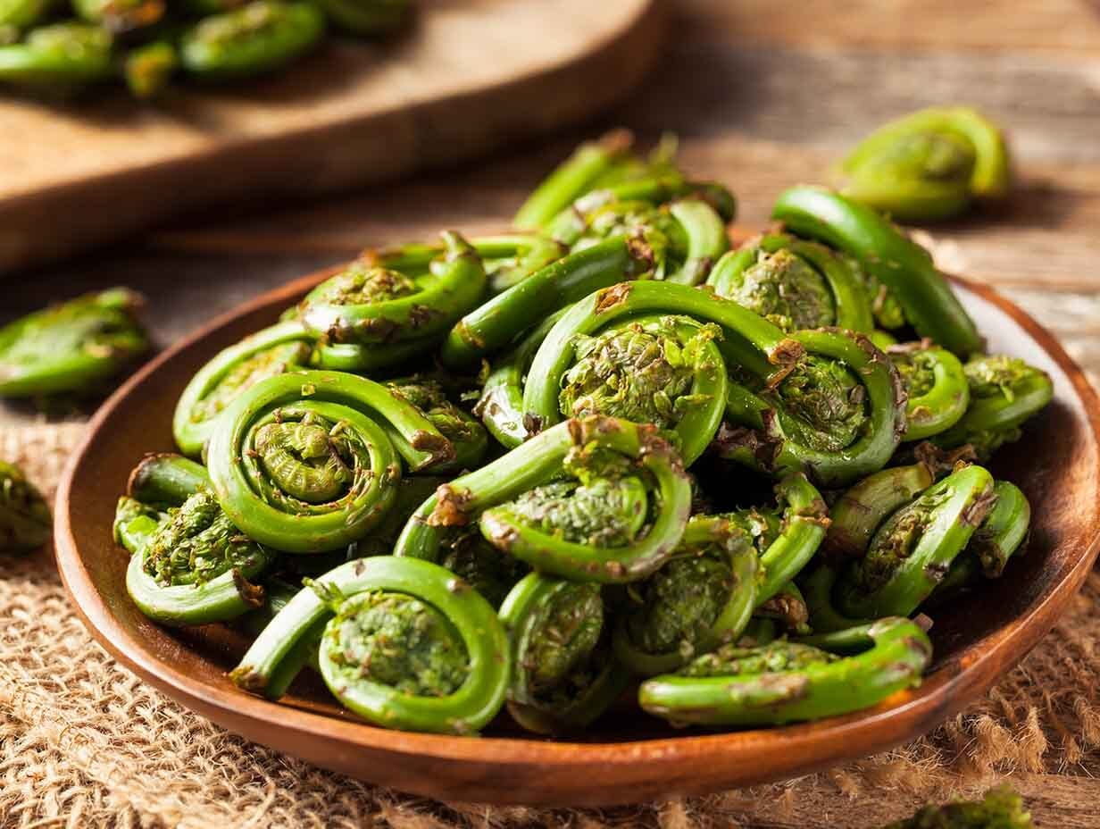 A bowl of cooked fiddlehead fruits