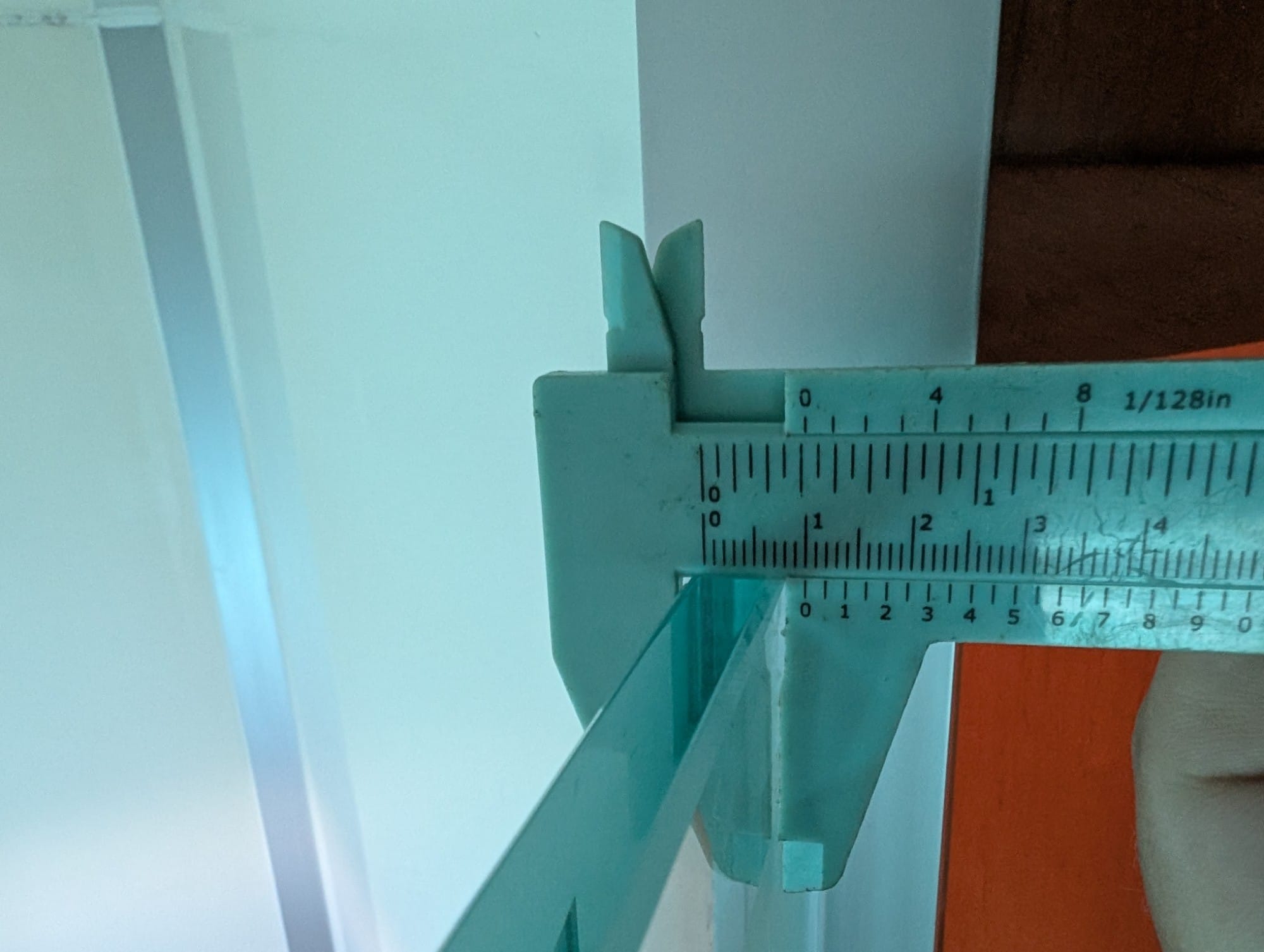Plastic vernier caliper measuring the thickness of a pane of glass