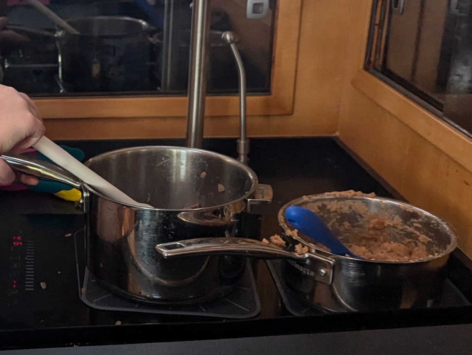 Two Cuisinart SmartNest stainless pans in use together on the induction cooktop in our boat galley