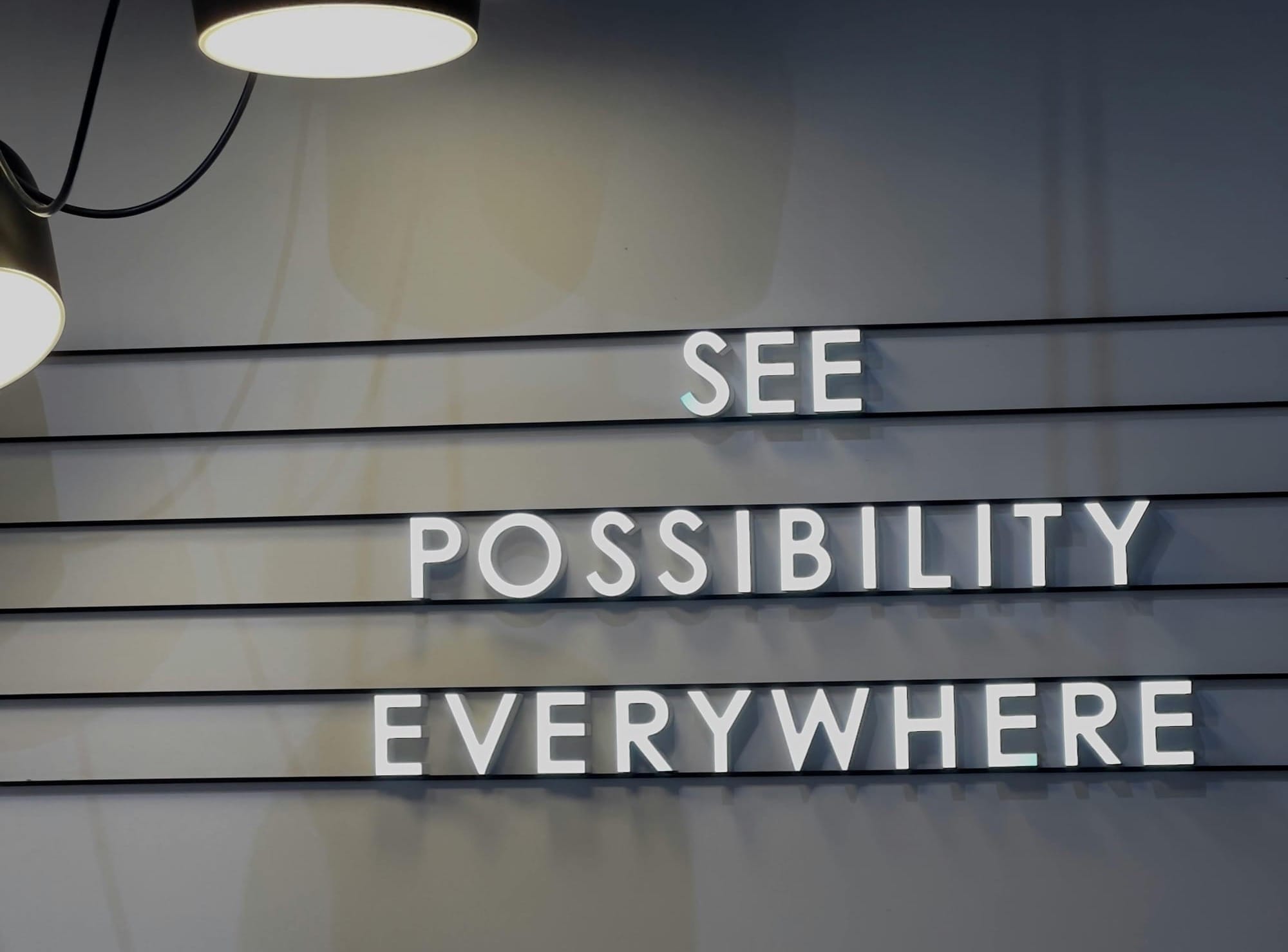 Signage on a wall which reads "See possibility everywhere."