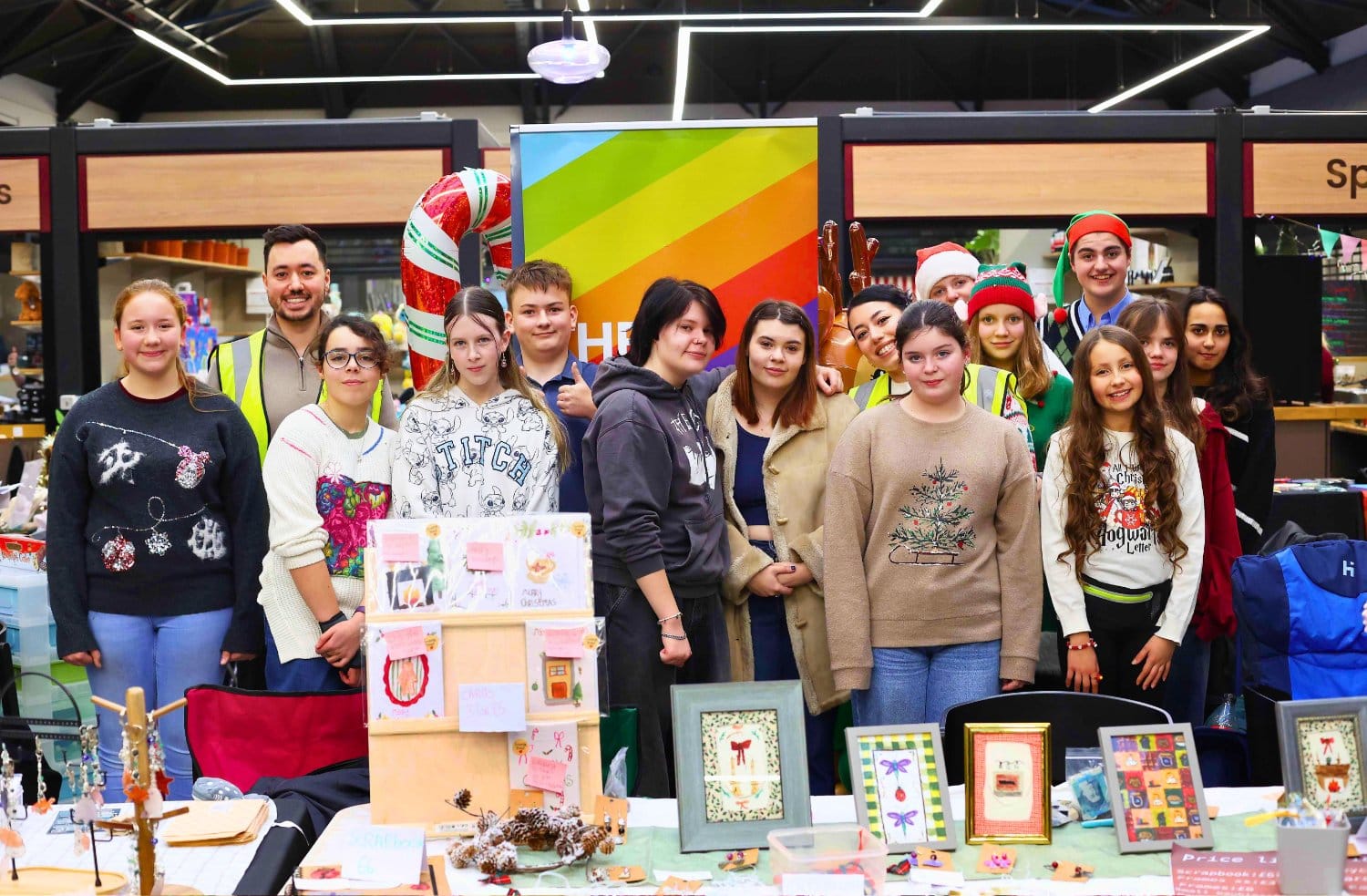 A group of 15 people stood behind a market stall, mostly teenagers with two adult organisers.