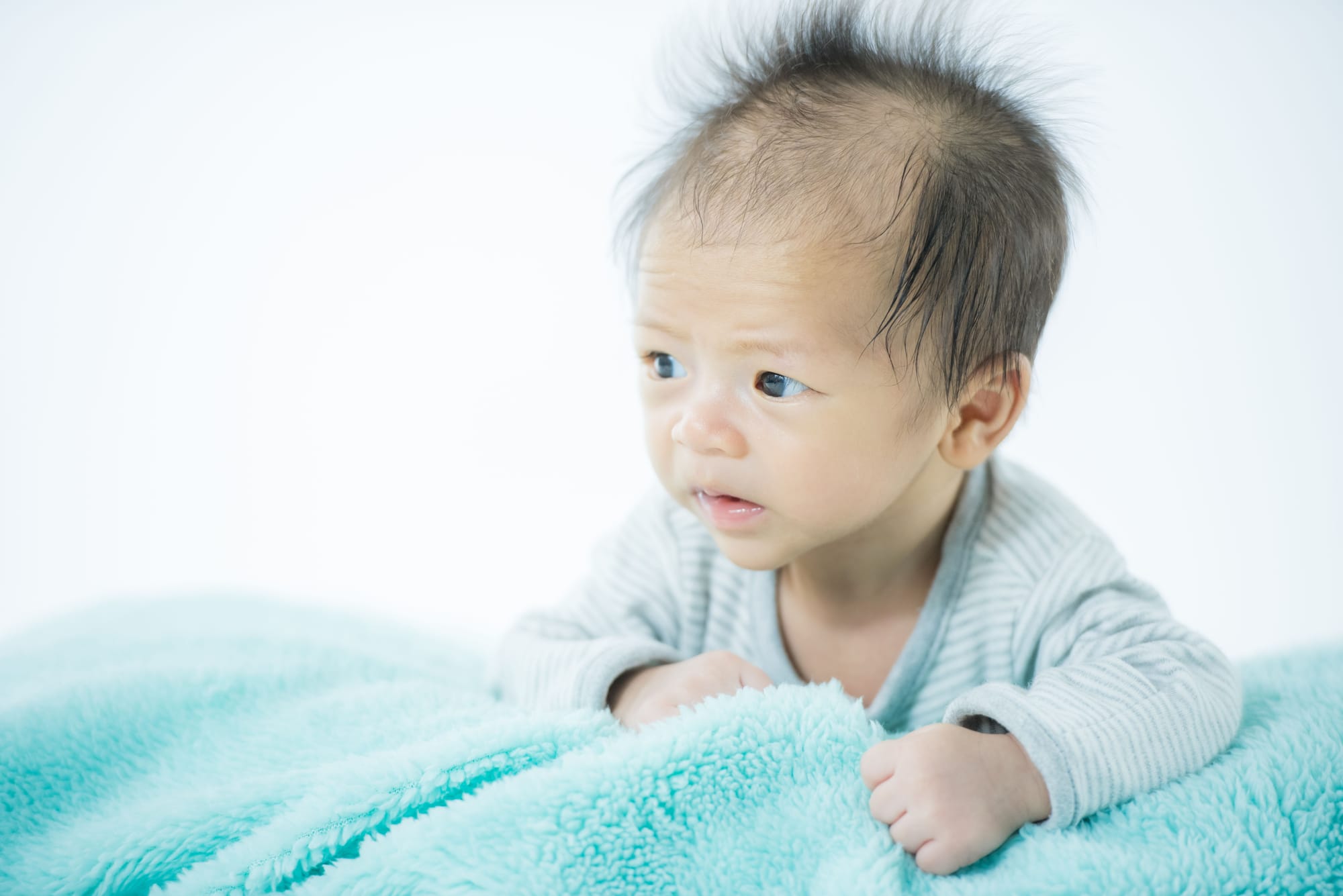 A photo of a baby clinging to a soft comforting blanket.