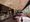 Interior dining room of Spacca Tutto restaurant at Palisades Village in Pacific Palisades, showing travertine and wood finishes with burgundy banquettes