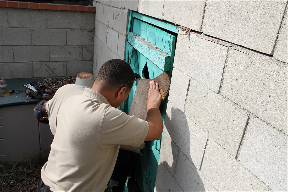 SHUT: Code Compliance seals the door of an abandoned house on Wednesday. The house is located in the Borderline Neighborhood. (Photo by Ashley Archibald)