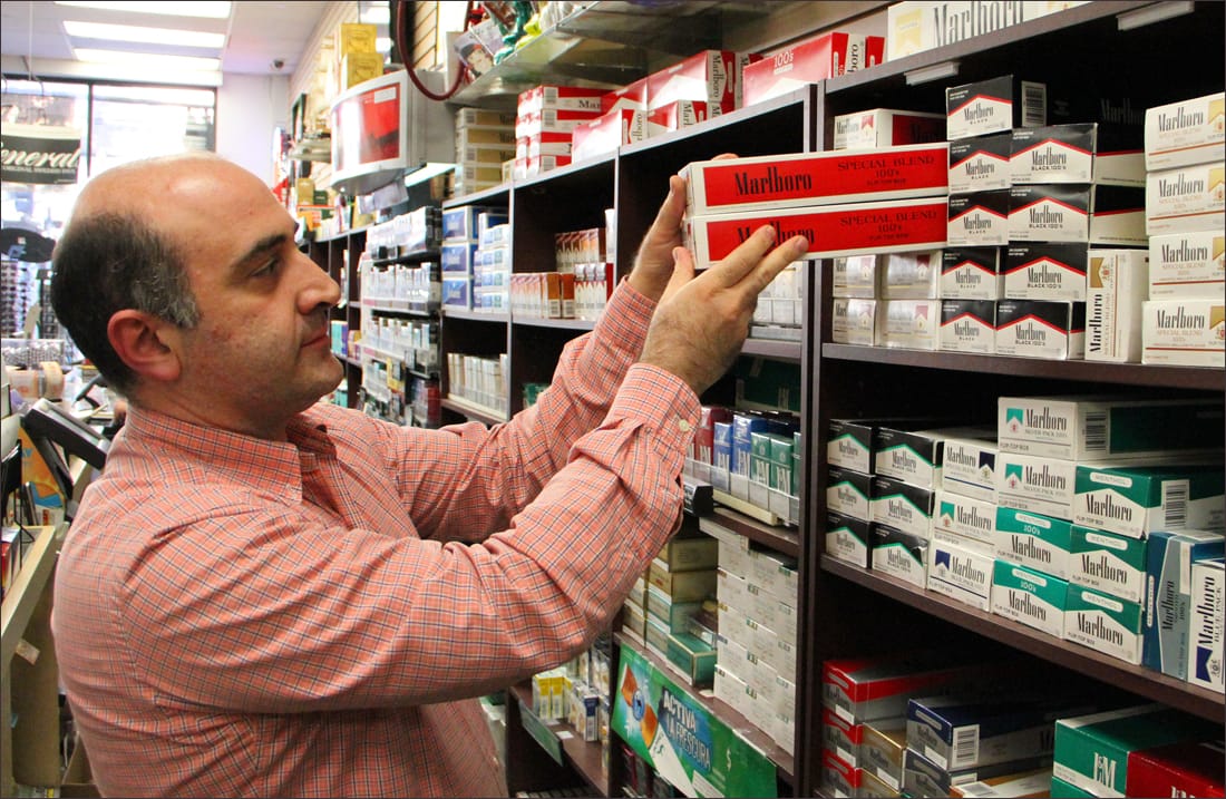 Moe Taherian, manager of Santa Monica Tobacco, stocks cigarettes at his store on Fourth Street on Wednesday. (Photo by Daniel Archuleta)