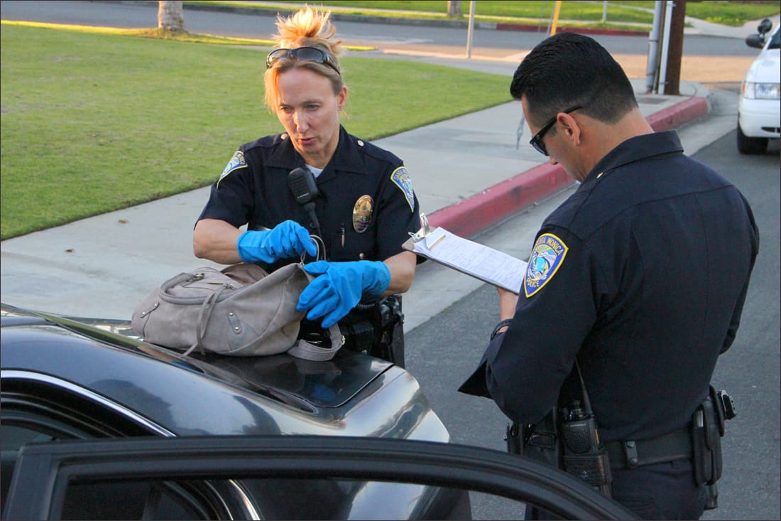 Santa Monica police search through the belongings found in a car that was involved in a persuit that led authorities through Venice and Santa Monica. Three suspects are said to be in custody with a fourth possibily at large in Venice. (Photo by Daniel Archuleta)