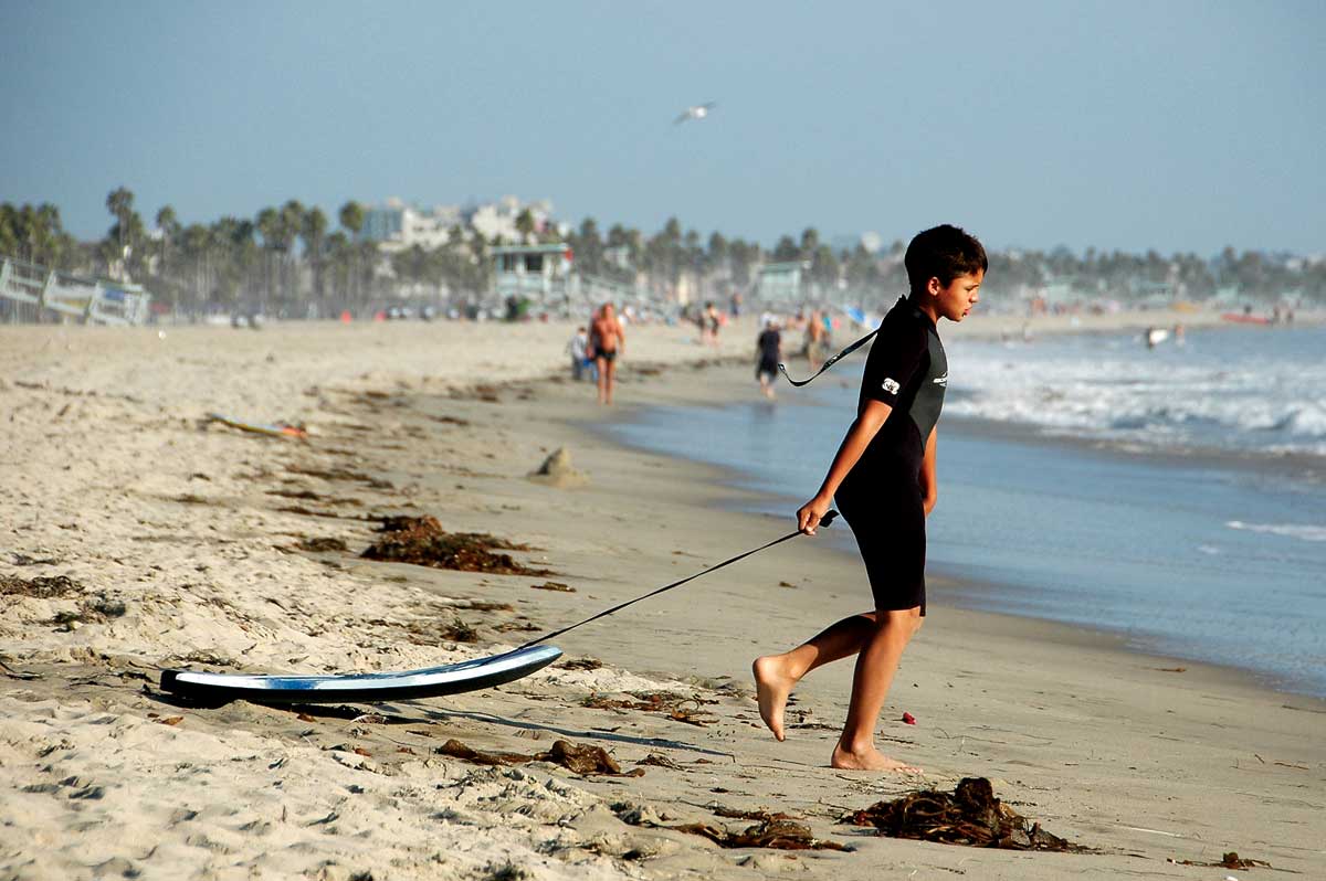 A young boogie boarder heads into the surf. Environmental watchdog Heal the Bay and UCLA student researchers are recommending people stay out of the ocean anywhere from five to 10 days following a rain storm, instead of the three recommended by county health officials. (File photo)