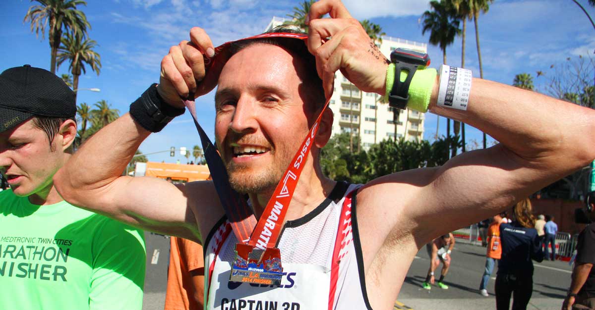 Phil McNally, from Eagle Rock, Calif., places his medal around his neck after fiinishing the 2014 Los Angeles Marathon on Sunday. (Daniel Archuleta daniela@www.smdp.com)