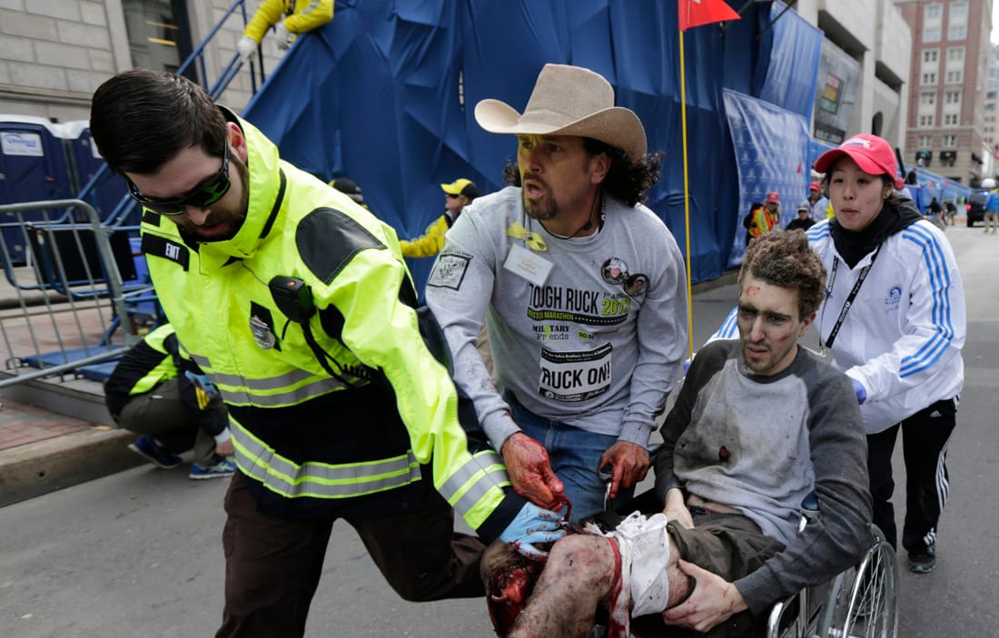 TRAGIC: Medical responders run an injured man past the finish line of the 2013 Boston Marathon following an explosion in Boston on Monday. (Associated Press)