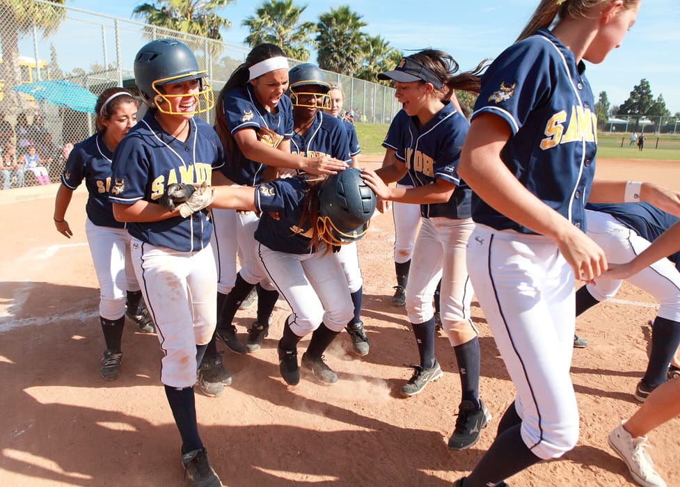 Santa Monica's softball team mobs teammate Sara Garcia after she hit her second home run of the game against No. 1 seeded Segerstrom on Tuesday on the road. Samohi went on to win the CIF-Southern Section Division 4 playoff game, 7-2. (Photo courtesy Wendy Perl)