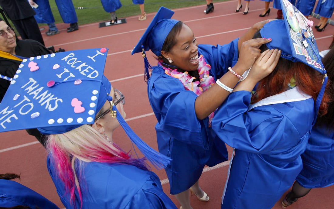 Chandell Beaver (center) makes last second adjustments to Mary Arroyo's cap before taking the stage during the Santa Monica College graduation ceremony on Tuesday. (Photo by Michael Yanow)