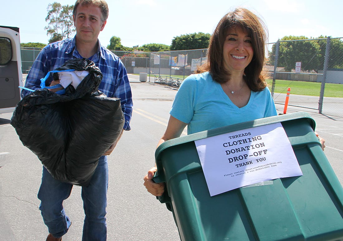 Jake Wachtel and Suzanne Goldman carry donated clothes Tuesday that they collected as part of their Threads nonprofit organization. (Photo by Daniel Archuleta)