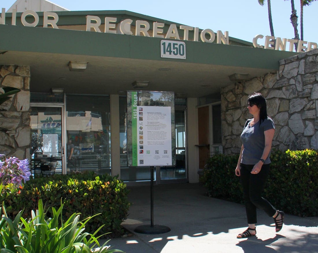 THE SPOT: A woman on Wednesday walks by a sign listing 1450 Ocean's class offerings. (Photo by Daniel Archuleta)