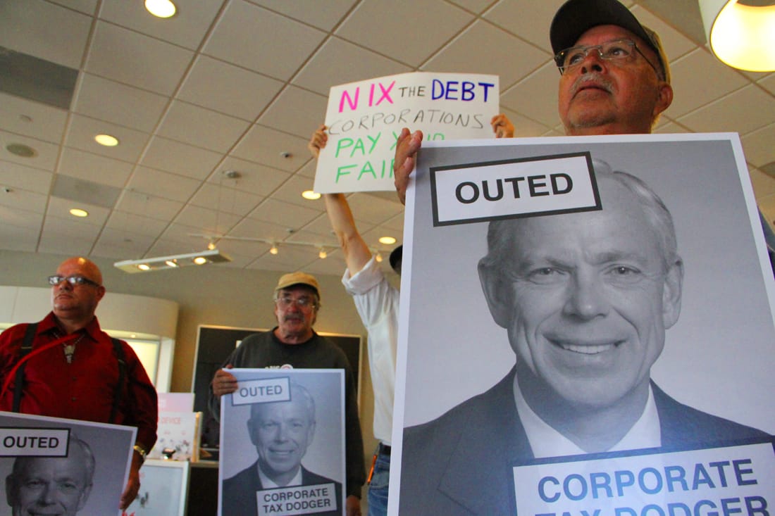 STANDING UP: A group of protesters gathered inside the Wilshire Boulevard Verizon store on Wednesday calling on the communications company to pay what they say is its fair share of corporate taxes. (Daniel Archuleta daniela@www.smdp.com)