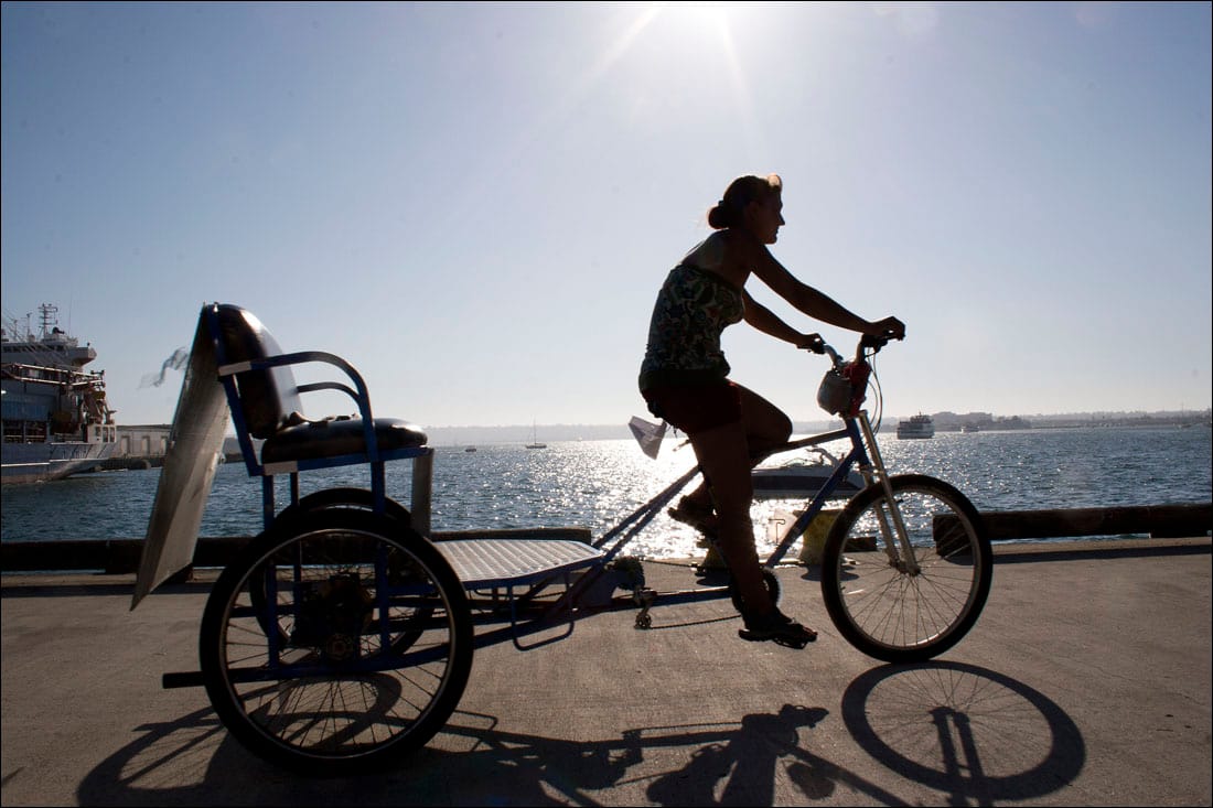 A pedicab operator pedals along the San Diego coast.