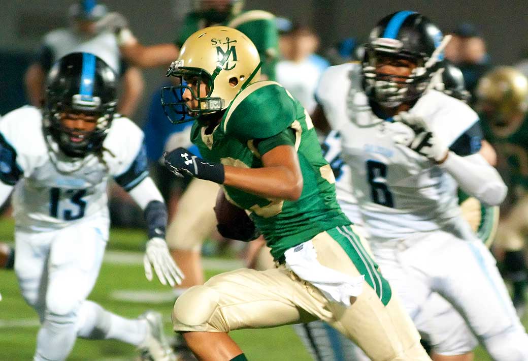 MOVING: St. Monica's Jason Thomas runs as Salesian defenders give chase last week at SMC. (Morgan Genser editor@www.smdp.com)