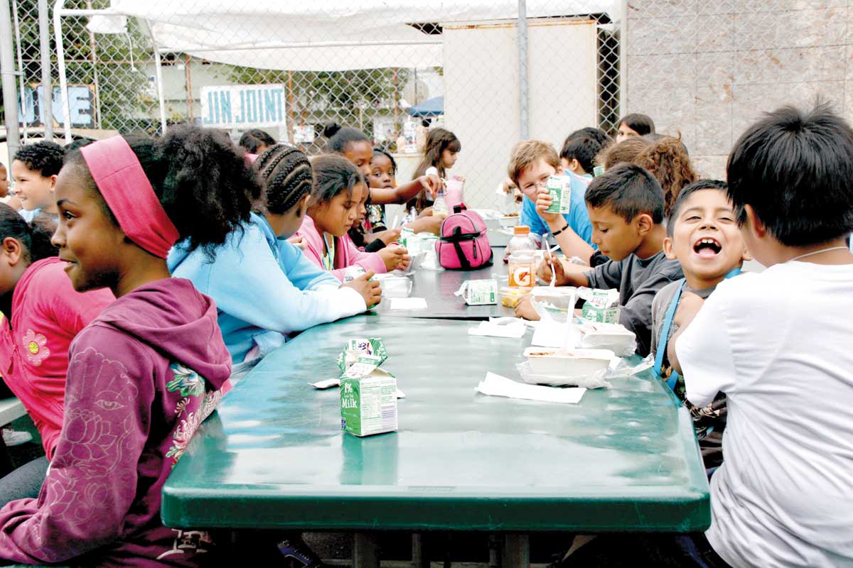 Children at the Santa Monica Boys and Girls Club have fun while eating their lunch. (File photo)